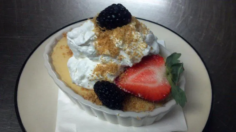 A homemade dessert topped with whipped cream, strawberries and blackberries