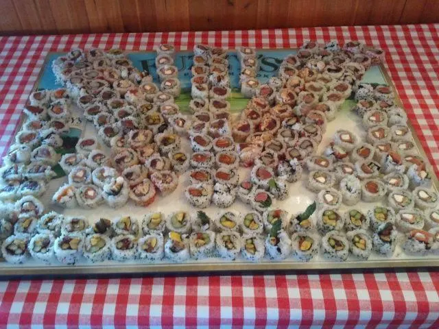 A tray of Oyster Creek sushi rolls on a red and white checked table